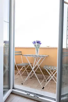 a table and chairs in a room with a window at Ion Apartment in Rome