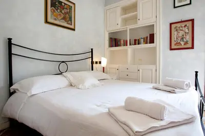 a bedroom with a white bed with two towels on it at Francesca e Anita in Rome