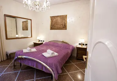 a bedroom with a purple bed and a mirror at Francesca e Anita in Rome