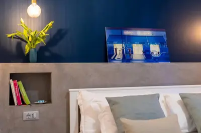 a bedroom with a blue wall and a bed with pillows at Brevi Roma Design Apartment in Rome