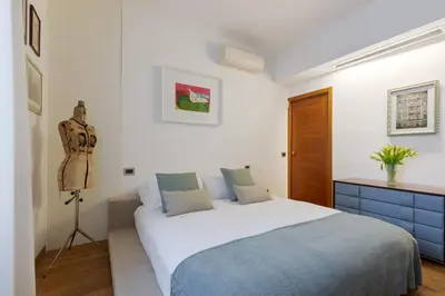 a bedroom with a bed and a dresser in it at Elegant Escape near the Vatican in Rome