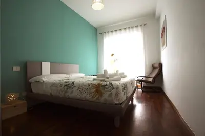a bedroom with a bed and a large window at Borbera Holiday House in Rome