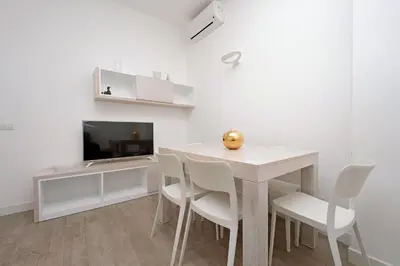 a dining room with a table and chairs and a tv at Vatican Claudia's apartment in Rome