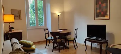 a living room with a tv and a table and chairs at Casa Ponte della Musica in Rome