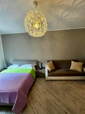 a bedroom with a bed and a couch and a chandelier at Residenza Cenci in Rome