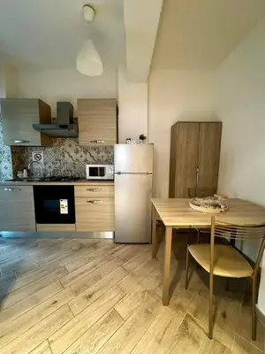 a kitchen with a table and a stainless steel refrigerator at Residenza Cenci in Rome