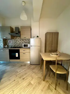 a kitchen with a table and a refrigerator at Residenza Cenci in Rome