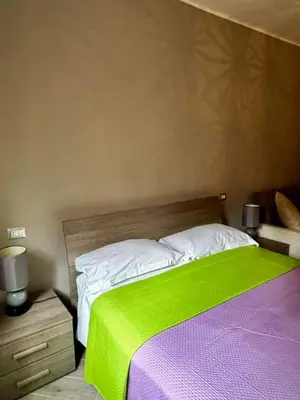 a bedroom with a bed with a green blanket on it at Residenza Cenci in Rome