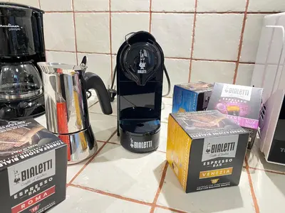 a coffee maker sitting on a counter next to boxes at Red House Trastevere San Pietro Bambin Gesú Sant Onofrio Appartamento Roma in Rome