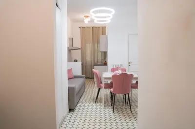 a living room with a table and pink chairs at Carpegna Sweet House - A few stops from the city centre in Rome
