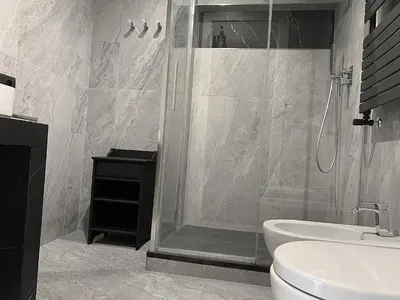 a bathroom with a shower and a toilet and a sink at Nox Romana Apartments - Vatican - Modern Apt with Cozy Balcony in Rome