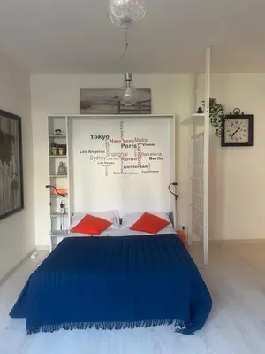 a bedroom with a large blue bed with red pillows at Chez Margot in Rome