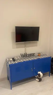 a blue bed with a flat screen tv on a wall at Chez Margot in Rome