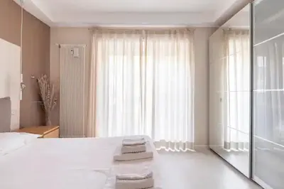 a bedroom with a white bed and a large window at Vatican Flat in Rome