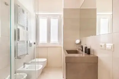 a white bathroom with a toilet and a sink at Vatican Flat in Rome