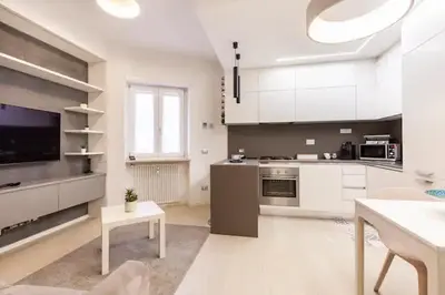 a large kitchen with white cabinets and a table at Vatican Flat in Rome