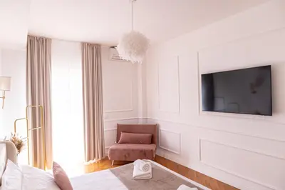 a white room with a tv and a chair at The Aristocats Apartment in Rome