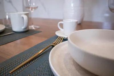 a wooden table with a white bowl and a fork at The Aristocats Apartment in Rome