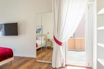 a bedroom with white walls and a sliding glass door at iFlat Luxury Penthouse near Trevi Fountain in Rome