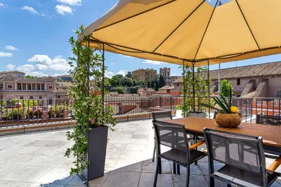 a table and chairs with an umbrella on a roof at iFlat Luxury Penthouse near Trevi Fountain in Rome
