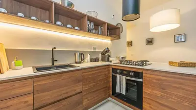 a kitchen with wooden cabinets and a stove top oven at Testaccio's Heart by Rentbeat in Rome