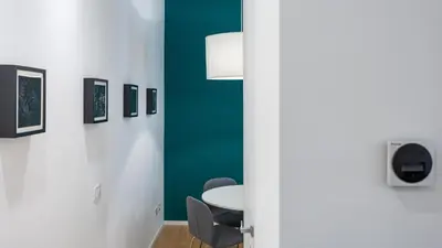 a room with a table and chairs and a green wall at Testaccio's Heart by Rentbeat in Rome