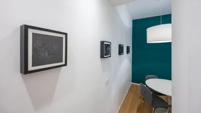 a dining room with a table and a green accent wall at Testaccio's Heart by Rentbeat in Rome
