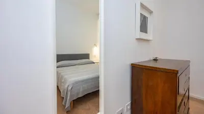 a bedroom with a bed and a wooden dresser at Testaccio's Heart by Rentbeat in Rome