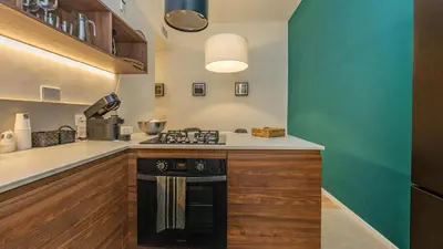 a kitchen with a stove and a green wall at Testaccio's Heart by Rentbeat in Rome