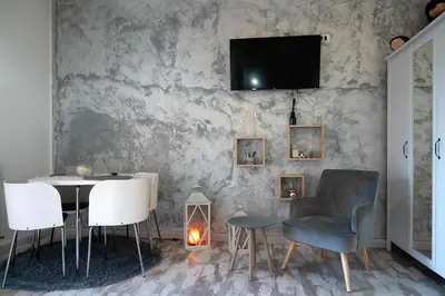 a dining room with a table and chairs and a tv on a wall at Magenta Collection Terrione 19 in Rome