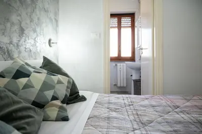 a bedroom with a bed with green pillows and a window at Magenta Collection Terrione 19 in Rome