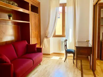 a living room with a red couch and a desk at DaliTourism - Colosseo Prestige Apartment in Rome