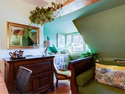 a living room with green walls and a mirror and a chair at Apartment Tiziano by Interhome in Rome