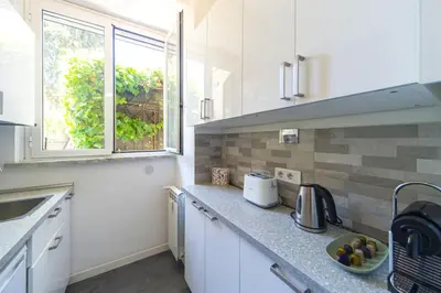 a kitchen with white cabinets and a sink and a window at Villino San Cosimato, nel cuore di Trastevere in Rome