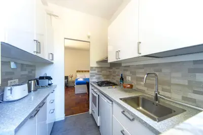 a kitchen with white cabinets and a sink at Villino San Cosimato, nel cuore di Trastevere in Rome