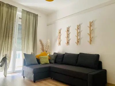 a living room with a black couch in front of a window at Casa Carlotta a Roma in Rome