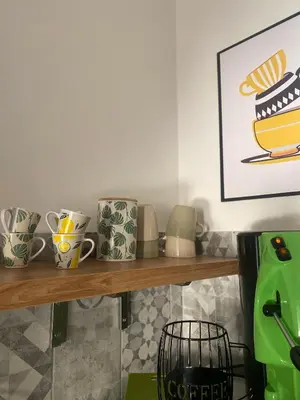 a shelf with cups and a picture of a cake at Casa Carlotta a Roma in Rome