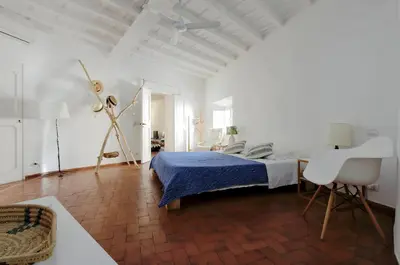 a white bedroom with a bed and a chair at Charming Minerva - My Extra Home in Rome