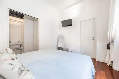 a white bedroom with a white bed and a television at Splendido appartamento a Villa Ada in Rome