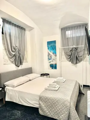two beds in a room with two windows at Rinascita Vatican Home in Rome