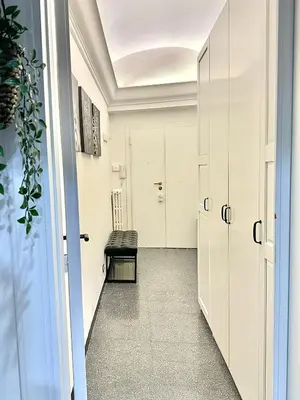 a hallway with white cabinets and a bench at Rinascita Vatican Home in Rome
