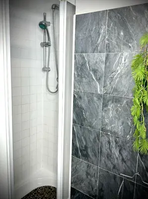 a bathroom with a shower with a tiled wall at Rinascita Vatican Home in Rome