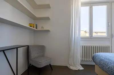 a bedroom with a bed and a chair and a window at Il Cupolone 3 camere a San Pietro in Rome