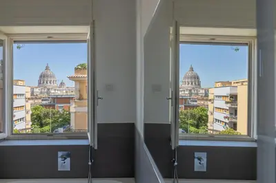 a bathroom with two windows and a view of a city at Il Cupolone 3 camere a San Pietro in Rome