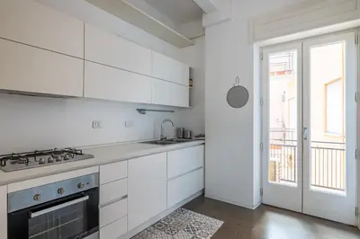 a kitchen with white cabinets and a stove top oven at Il Cupolone 3 camere a San Pietro in Rome