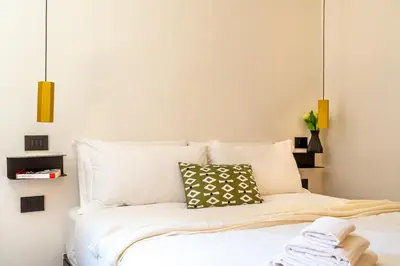 a bedroom with a bed with white sheets and pillows at iFlat Campo de' Fiori modern apartment in Rome