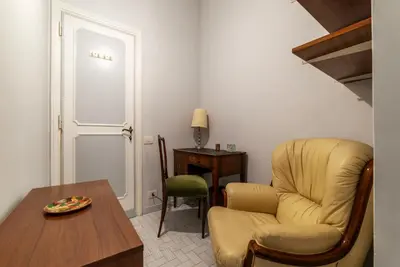 a living room with a chair and a table at GuestHost - Villa Pamphili & Vaticano Cozy Apartment in Rome