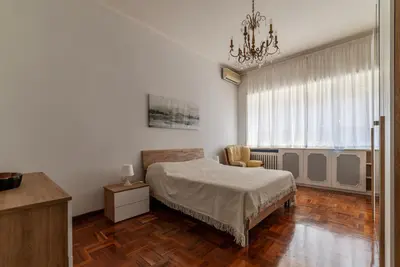 a bedroom with a bed and a chair and a window at GuestHost - Villa Pamphili & Vaticano Cozy Apartment in Rome