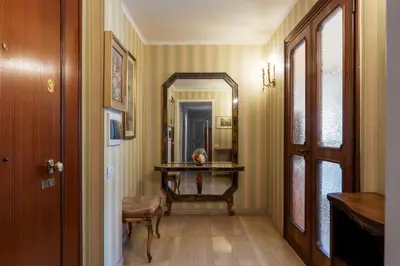 a hallway with a mirror and a table with a chair at GuestHost - Villa Pamphili & Vaticano Cozy Apartment in Rome