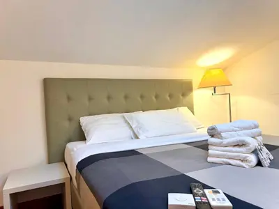 a hotel room with a bed and a lamp and towels at Attic Garden in Rome